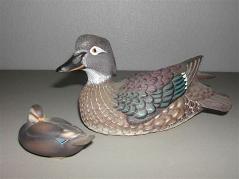  DUCKS UNLIMITED DUCK DECOY, special edition for 1987-88 (as stated on brass medallion), carved and stained pine body with folded wings, glass eyes, signed by artist Tom Taber, overall length 21 1/4". DECORATIVE CANADIAN GOOSE DECOY, hand carved laminated wood body, painted and stained with Canadian goose markings, glass eyes, signed on bottom ... 